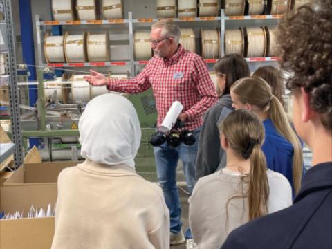 Ein Mitarbeiter der Firma Westdeutsche Dochtfabrik erläutert Jugendlichen die Funktion einer Maschine beim Tag der offenen Tür in Nettetaler Betrieben
